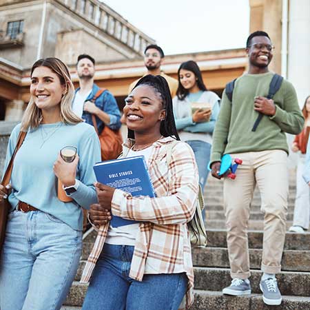 college students carrying books walking down stairs