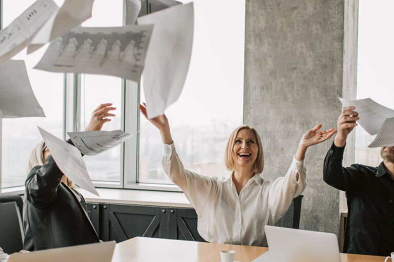 woman throwing papers in the air during office meeting