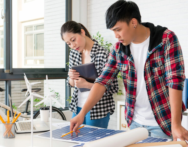 two people studying model of windmill